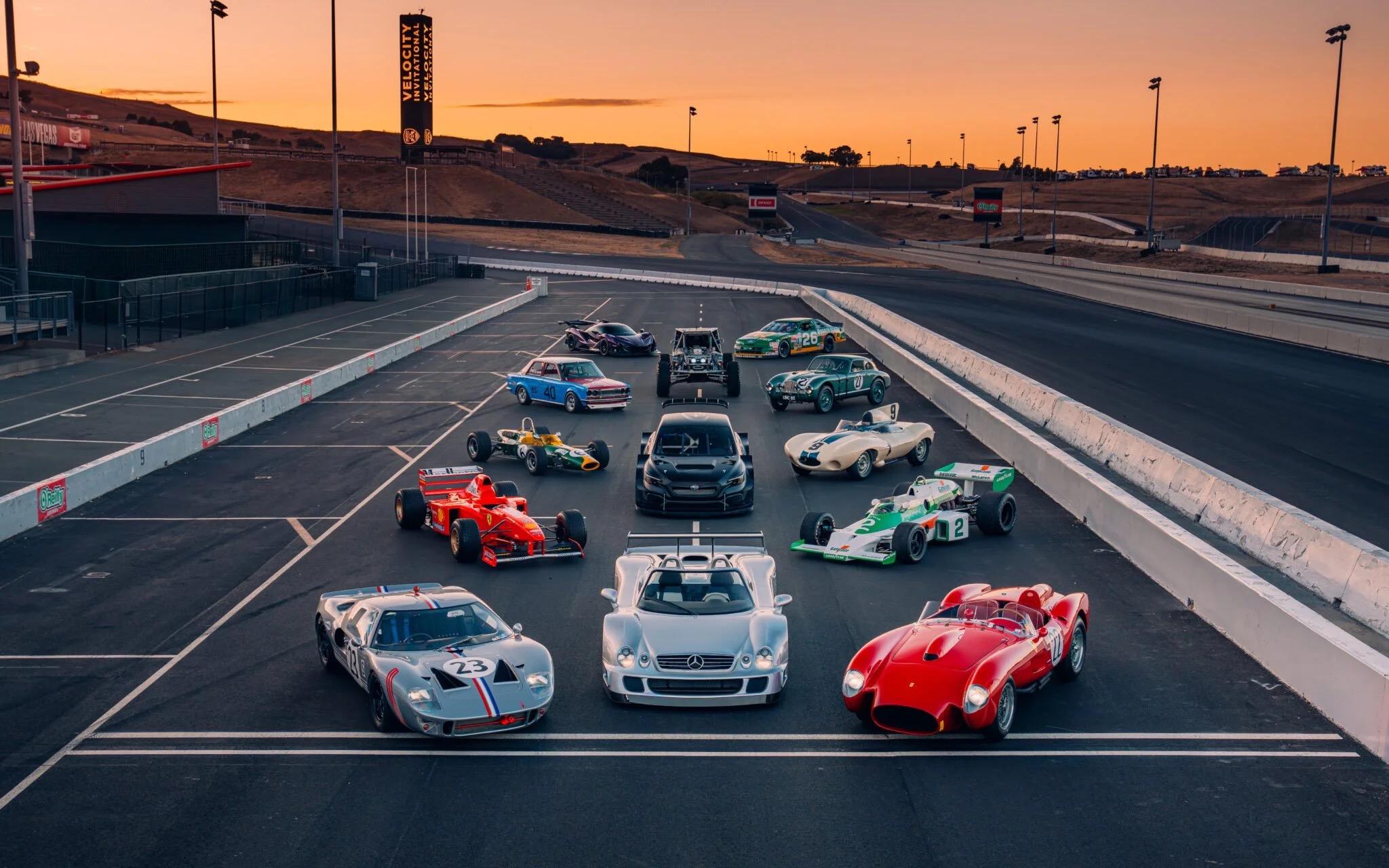 Classic and historic race cars lined up at Sonoma Raceway at sunset